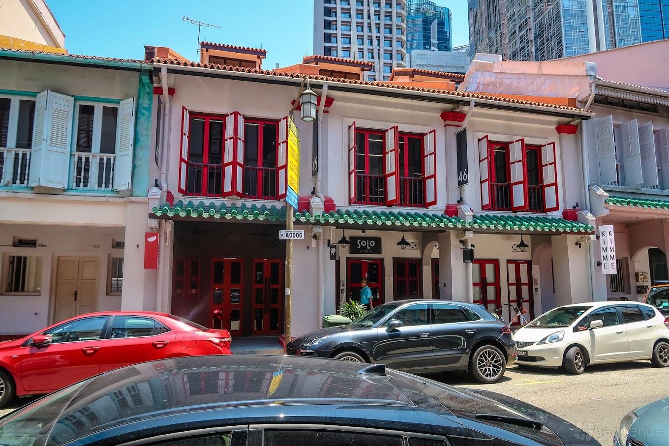 A restaurant with red-framed windows and doors set in a heritage shophouse exterior at Solo Ristorante.