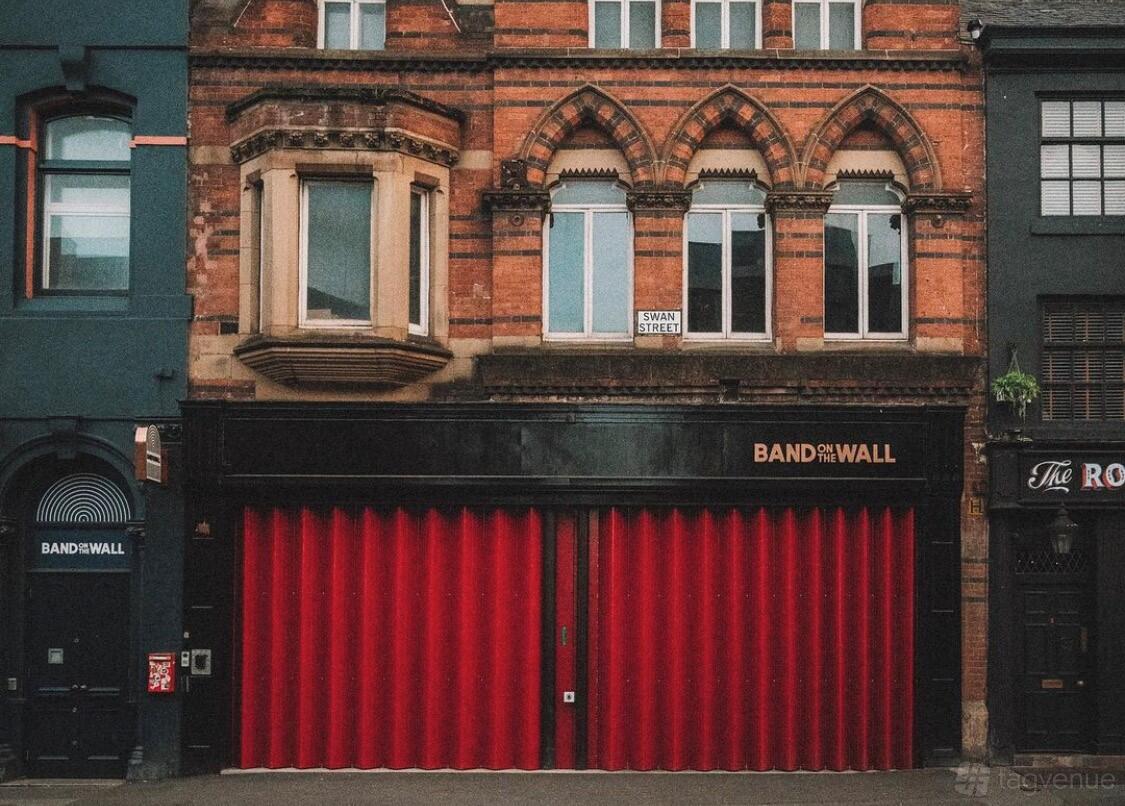 A versatile event space with a red brick facade and bold red doors at Band on the Wall.