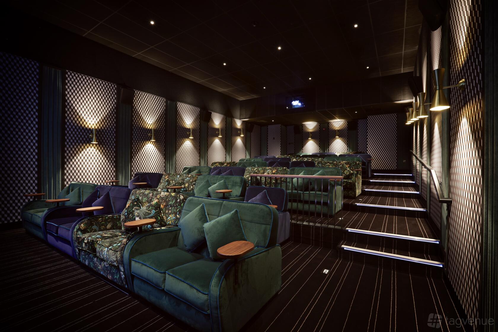 An auditorium with plush velvet seats, patterned walls, and individual side tables at Everyman Liverpool.