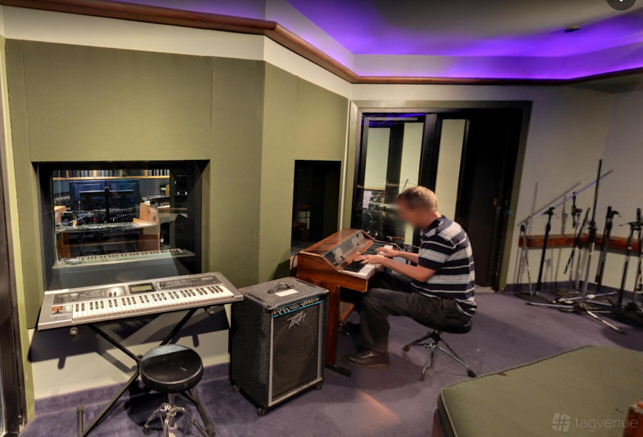 A recording studio with soundproof walls, keyboard setup, and microphones at Harris Institute.