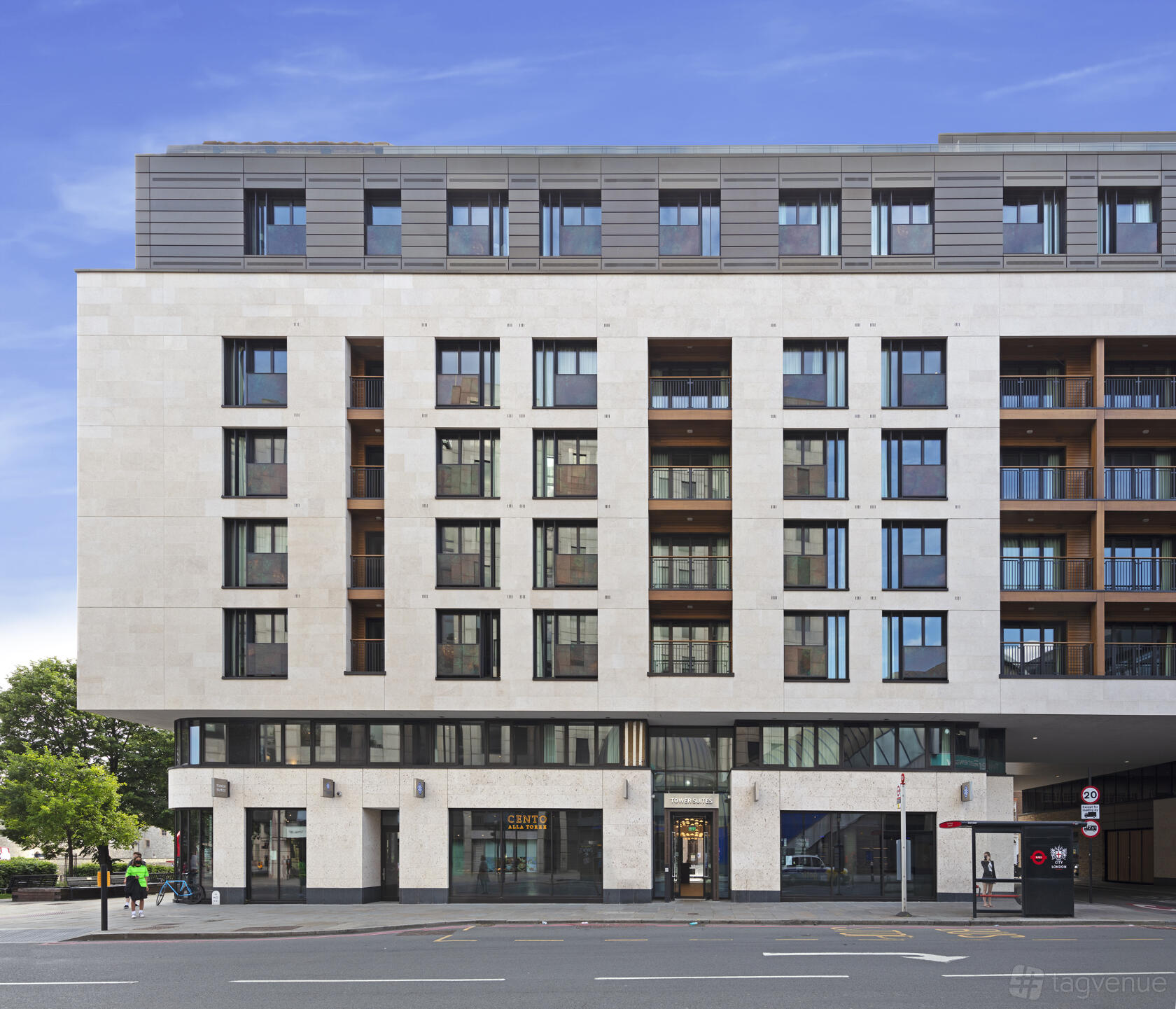 A hotel with a modern stone facade and large windows at Tower Suites by Blue Orchid.