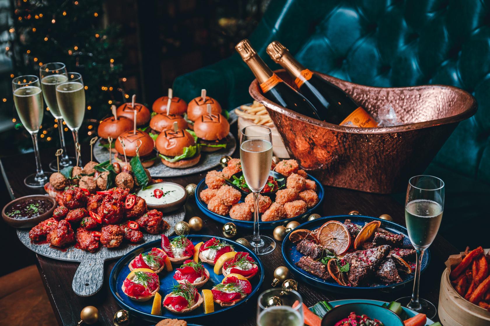 A cocktail bar event space with sharing platters, sliders, fried bites, and glasses of champagne at Manahatta Temple Street.