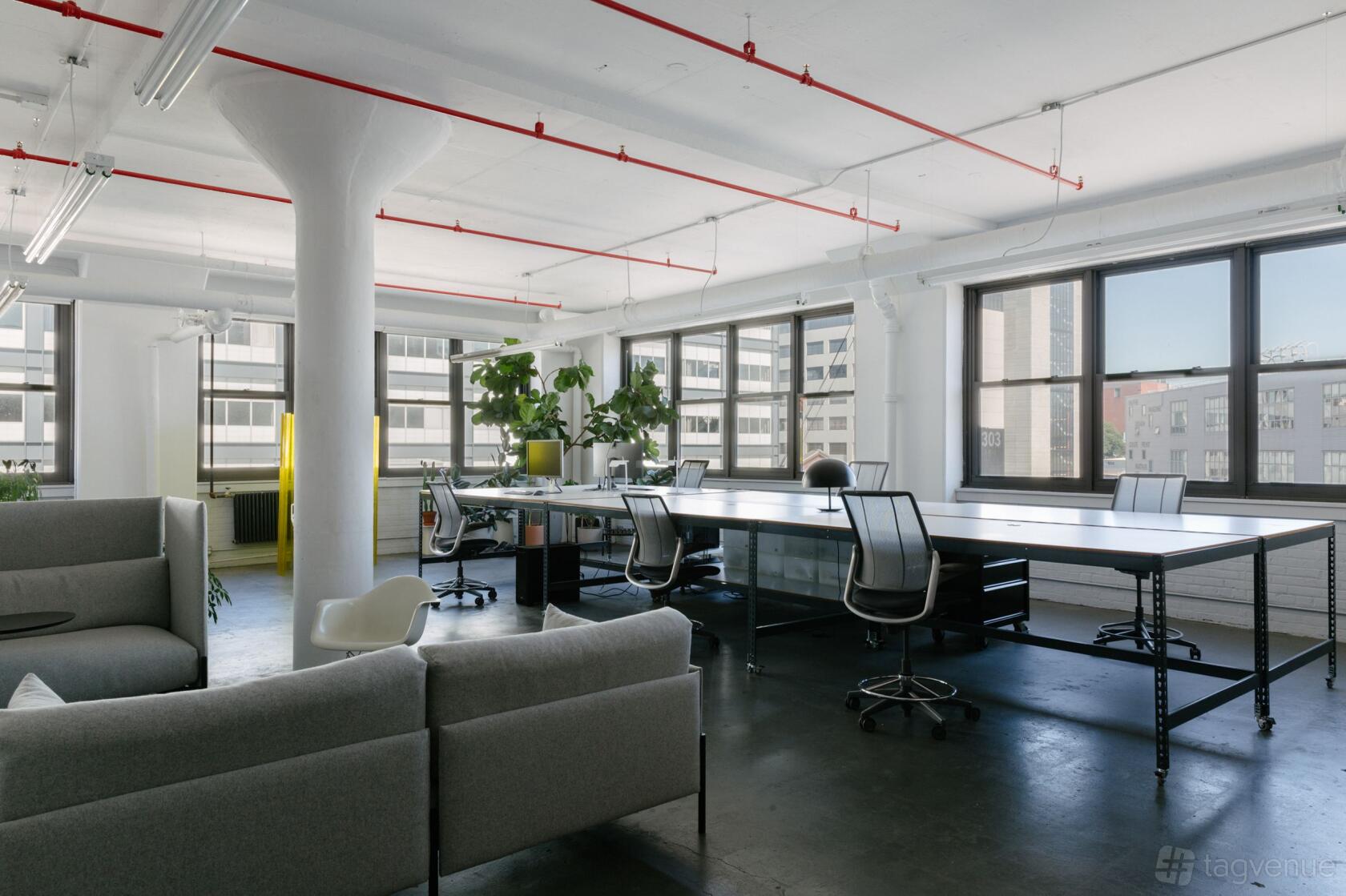 An event venue with large windows, black tables, office chairs, and potted plants at Casa Demo.