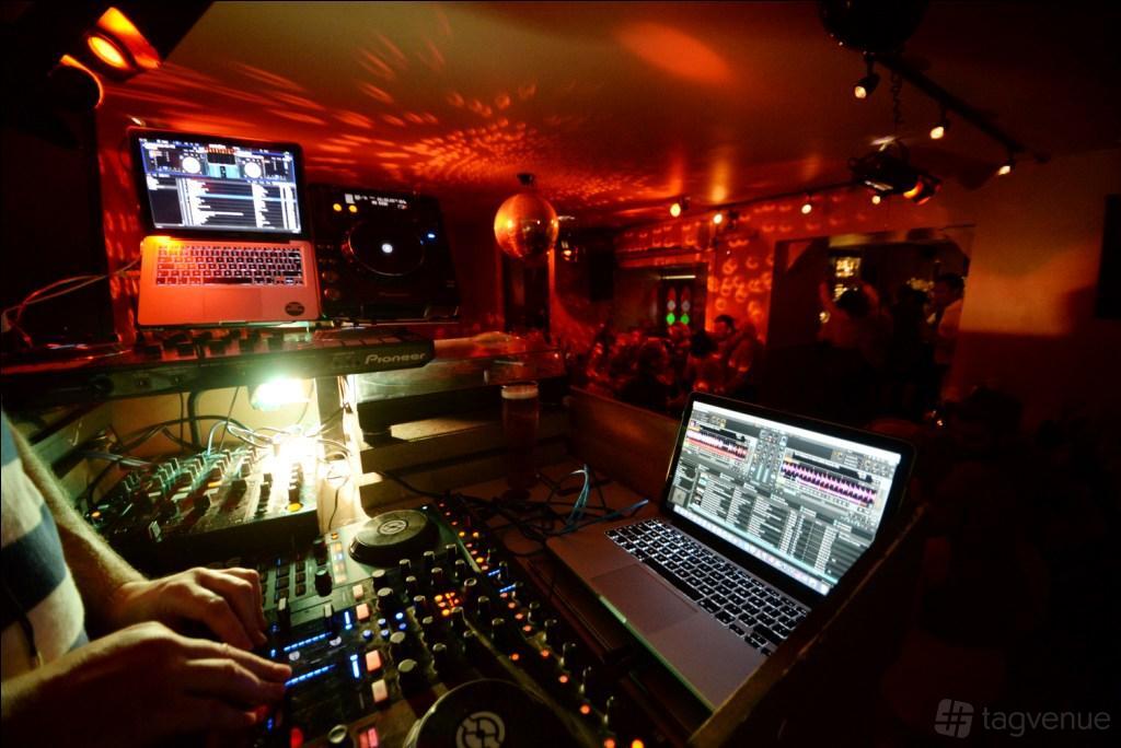 A function room with DJ booth, mixing equipment, and colorful lighting at The Chapel Bar.
