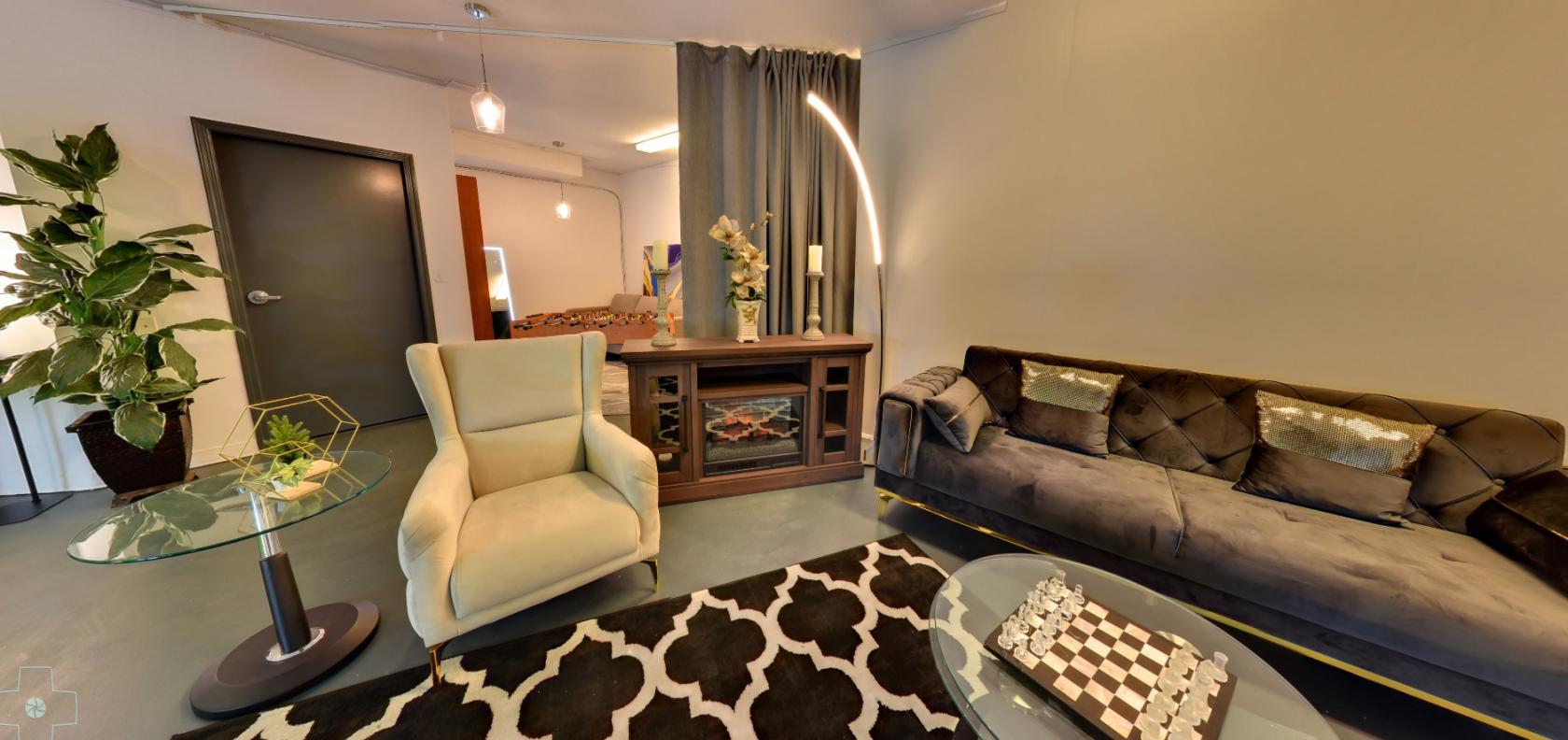 A TV studio set with a velvet sofa, armchair, patterned rug, and chessboard table at Mirage Studio.