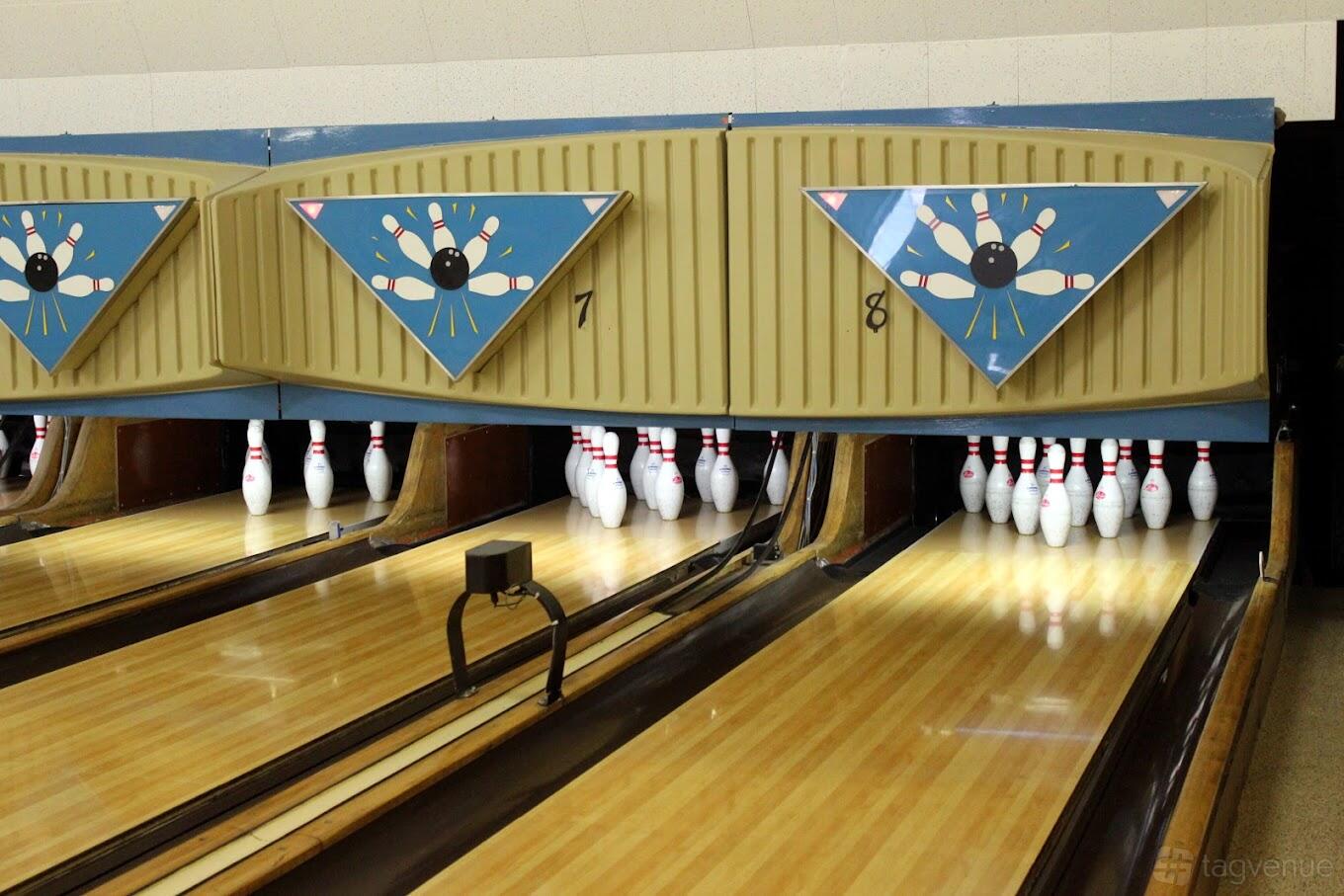 A bowling alley with polished wooden lanes and vintage lane markers at Boulder Bowl.