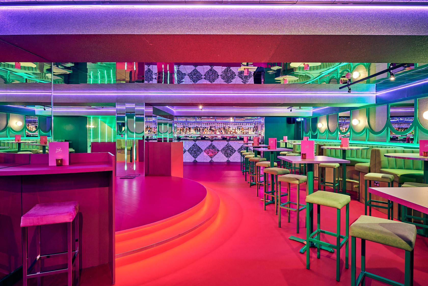 An event space in a cocktail bar with neon lighting, mirrored walls, and high tables at Tonight Josephine Liverpool.