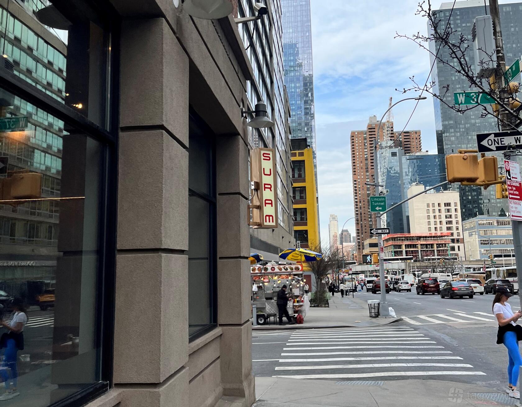 A restaurant with a vertical neon sign on a city corner with street views at Suram - Sushi & Ramen.