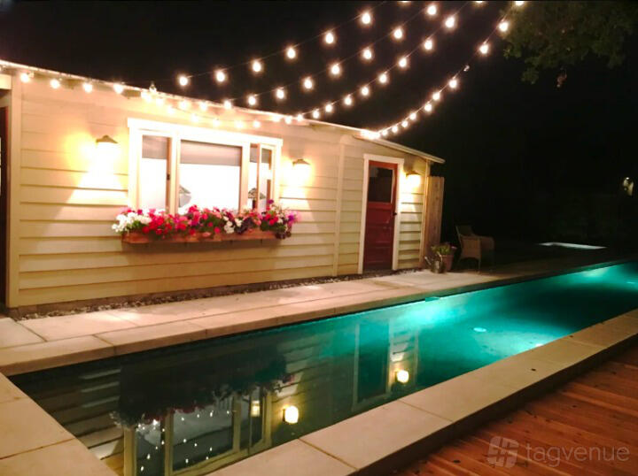 A house with a lap pool, string lights overhead, and flower boxes on the windows at Lap Pool Guesthouse.