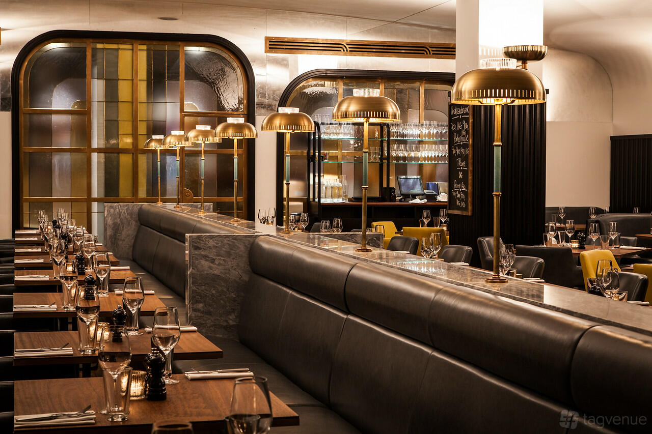 A restaurant with leather banquette seating, wooden tables, and brass pendant lighting at Hawksmoor Knightsbridge.
