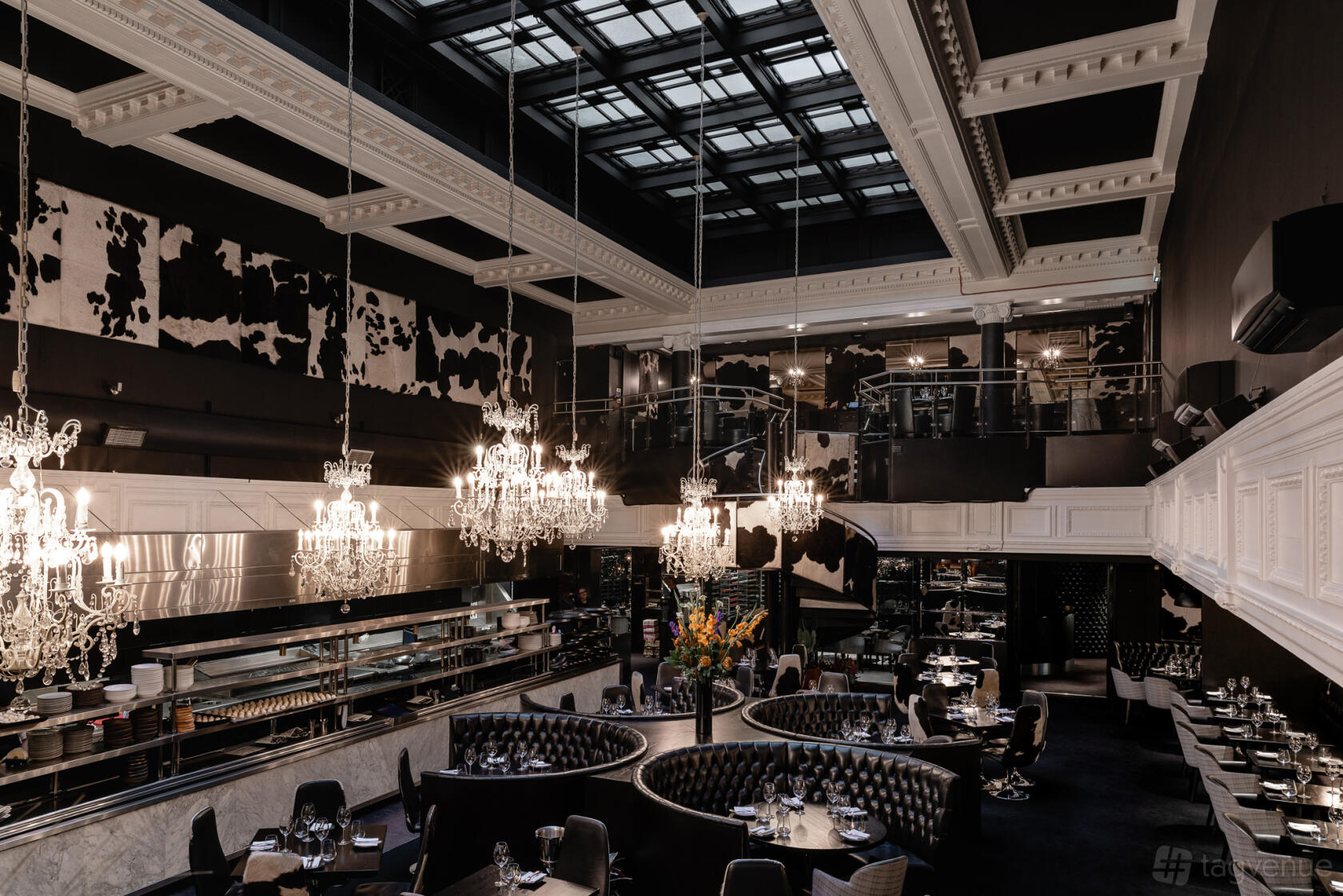 A restaurant with tufted leather booths, chandeliers, high ceilings, and cowhide wall accents at Gaucho Manchester.