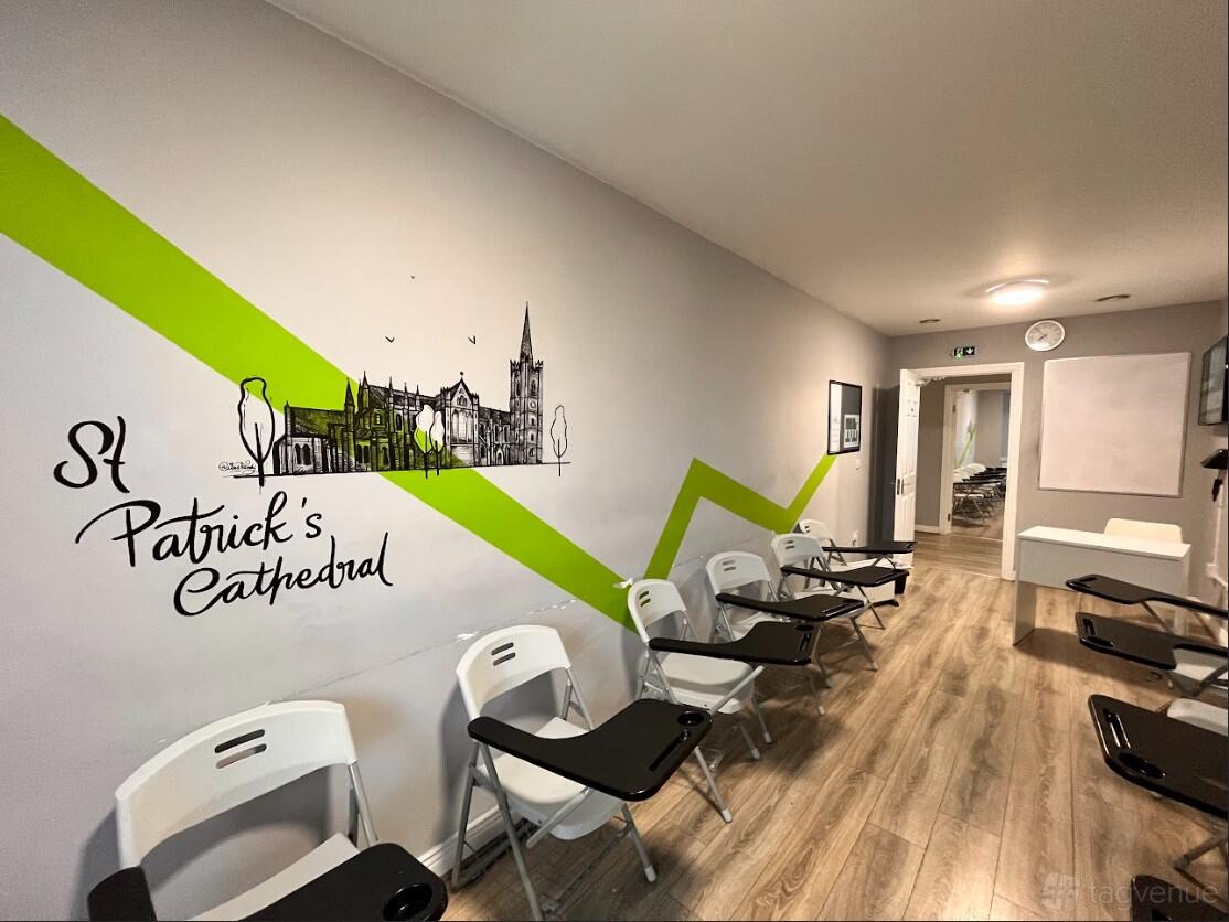 A classroom with folding chairs, wood flooring, and a mural of St Patrick's Cathedral at North Great George's Street.
