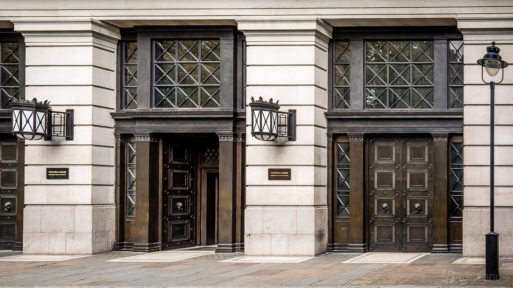 A historic building with large wooden doors, decorative ironwork, and lantern-style wall lights at The Bloomsbury Ballroom.