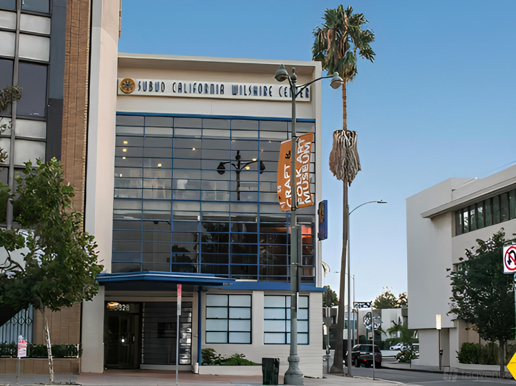 A meeting centre with a glass facade, blue trim, and palm trees at Wilshire Center.