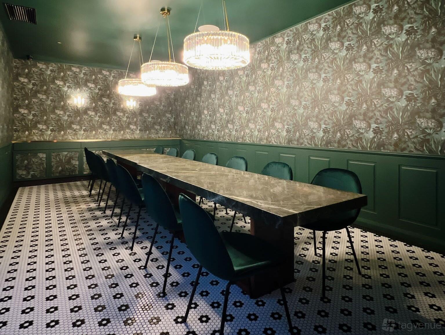 A dining room with a long marble table, emerald velvet chairs, and floral wallpaper at Father's Office Downtown - Flinders Lane.