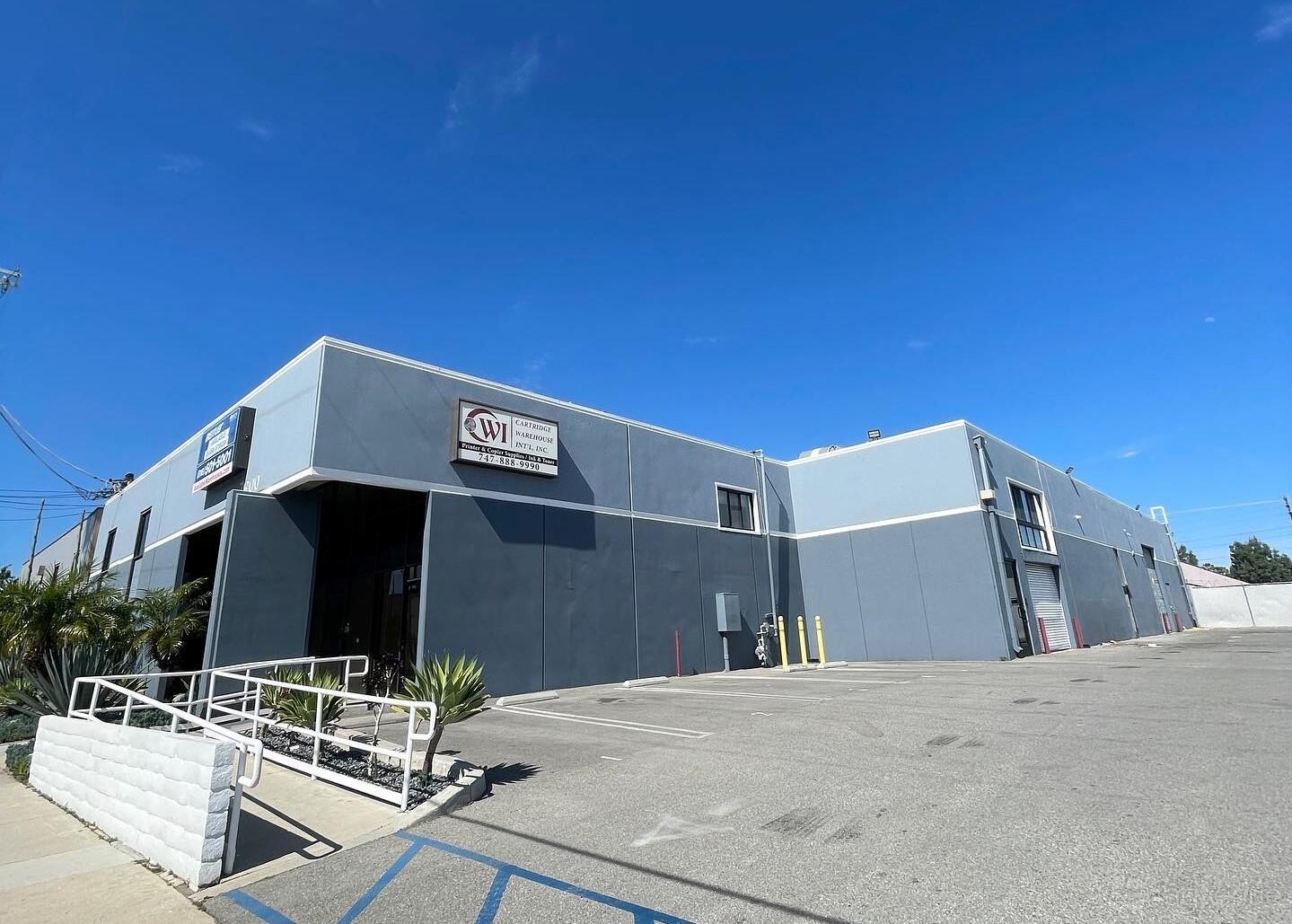 A film and photo studio with a gray exterior facade, large garage doors, and accessible entry ramp at Huge Black Void Sound Stage.