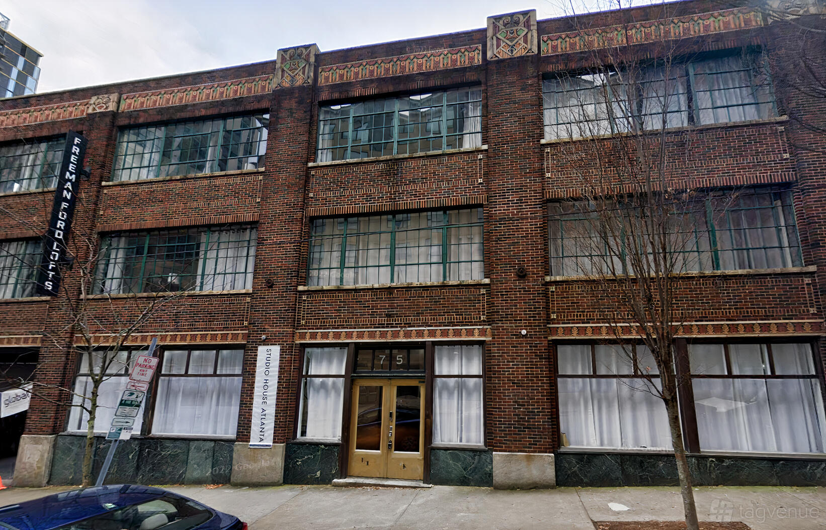 A film and photo studio with a brick facade, tall windows, and an art deco entrance at Studio House Atlanta.