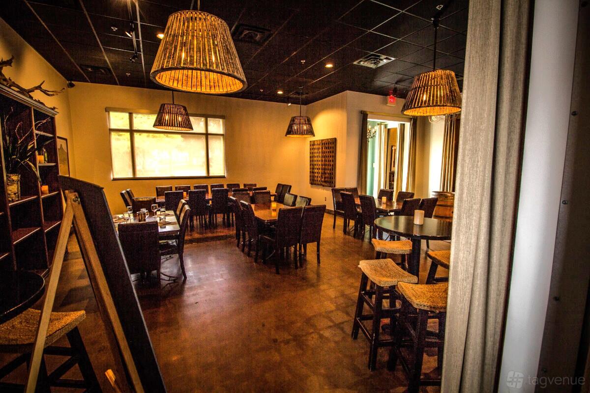 A function room with wooden tables, wicker pendant lighting, and large windows at Times Ten Cellars.