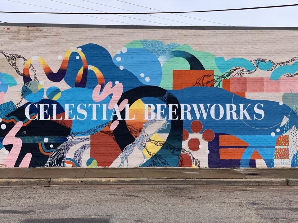 A pub with a colorful abstract mural featuring the name 'Celestial Beerworks' on the exterior wall at Celestial Beerworks