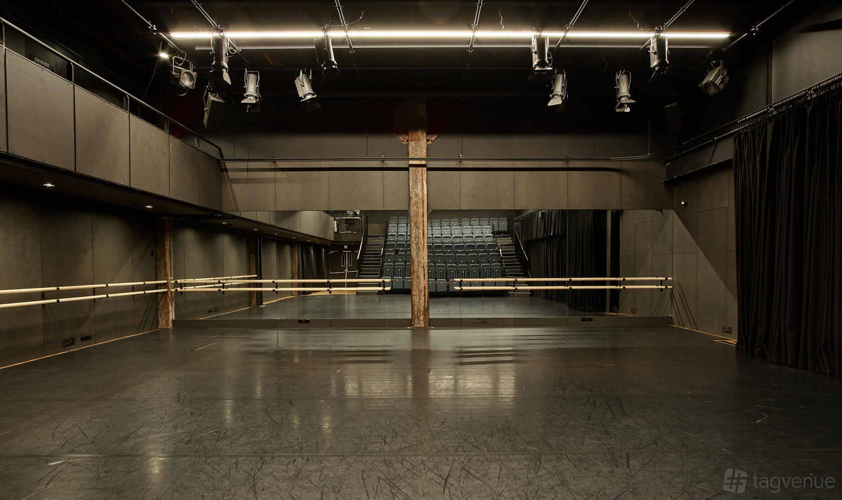 A dance studio with mirrored walls, ballet barres, and theater-style seating at Sydney Dance Company.