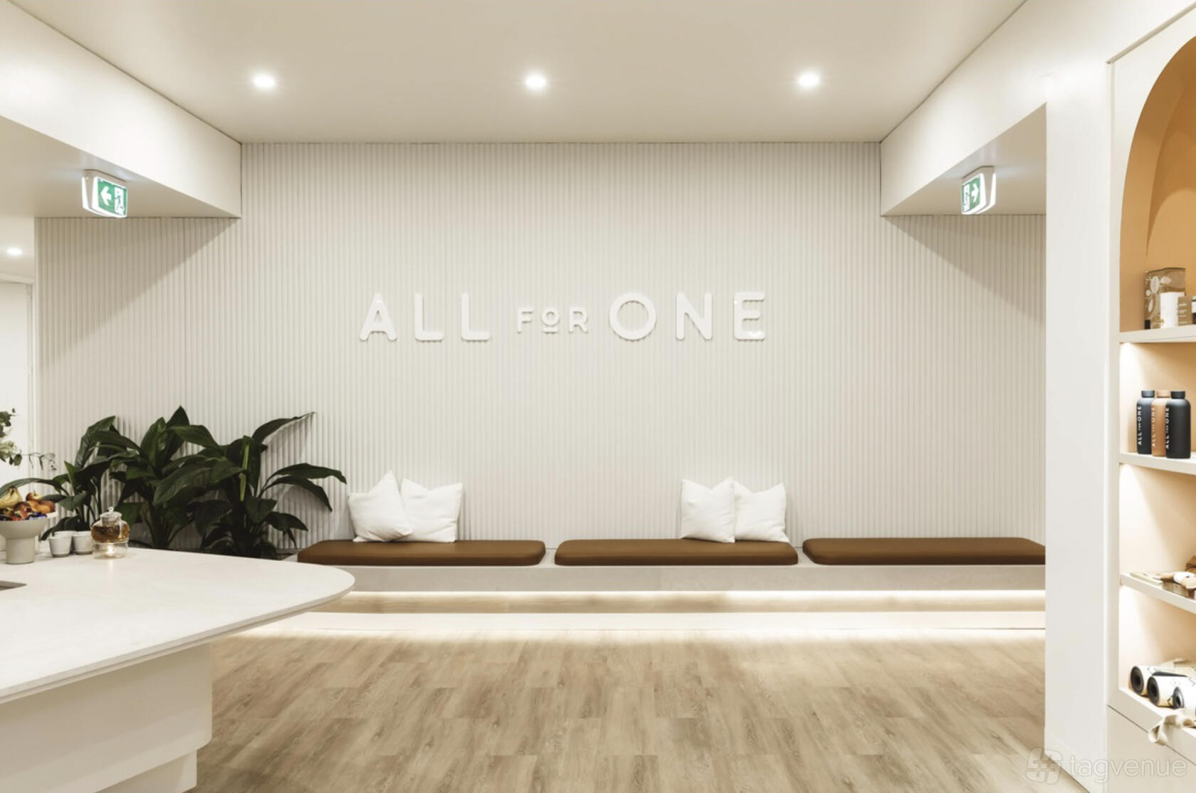 A photo studio with built-in bench seating, decorative pillows, and indoor plants at All For One Hampton East.