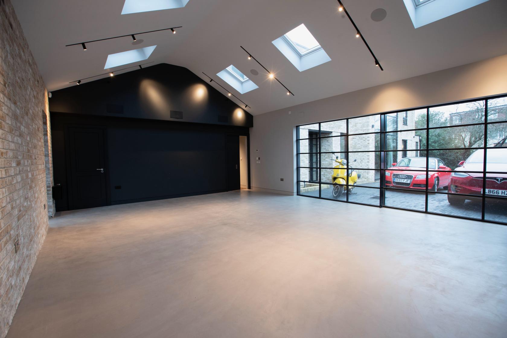 A photo studio with large skylights, exposed brick wall, and floor-to-ceiling windows at On Kew.