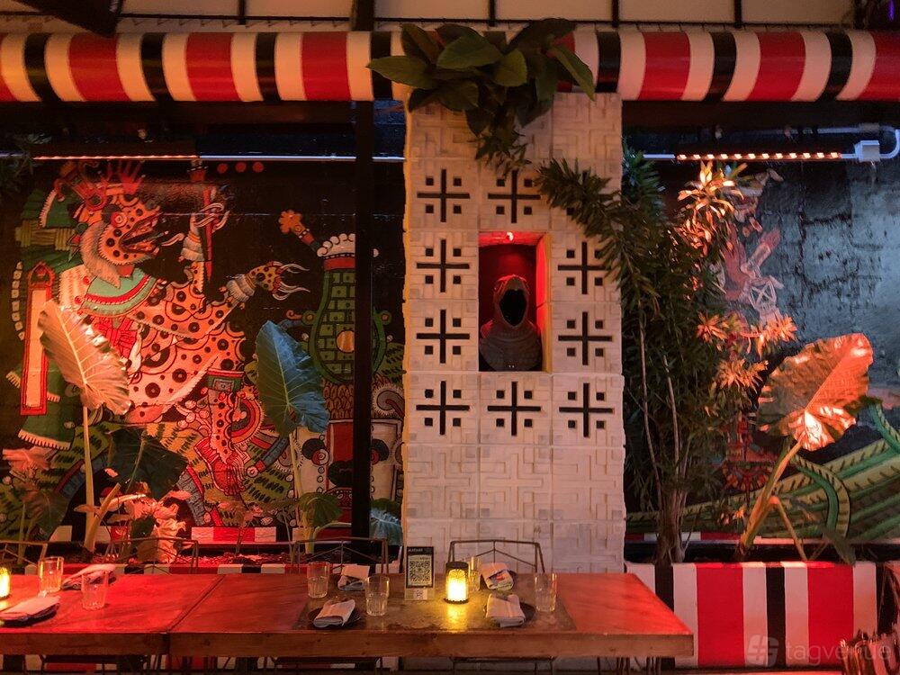 An event space with mural walls, tropical plants, and candlelit tables at Mayami Wynwood.