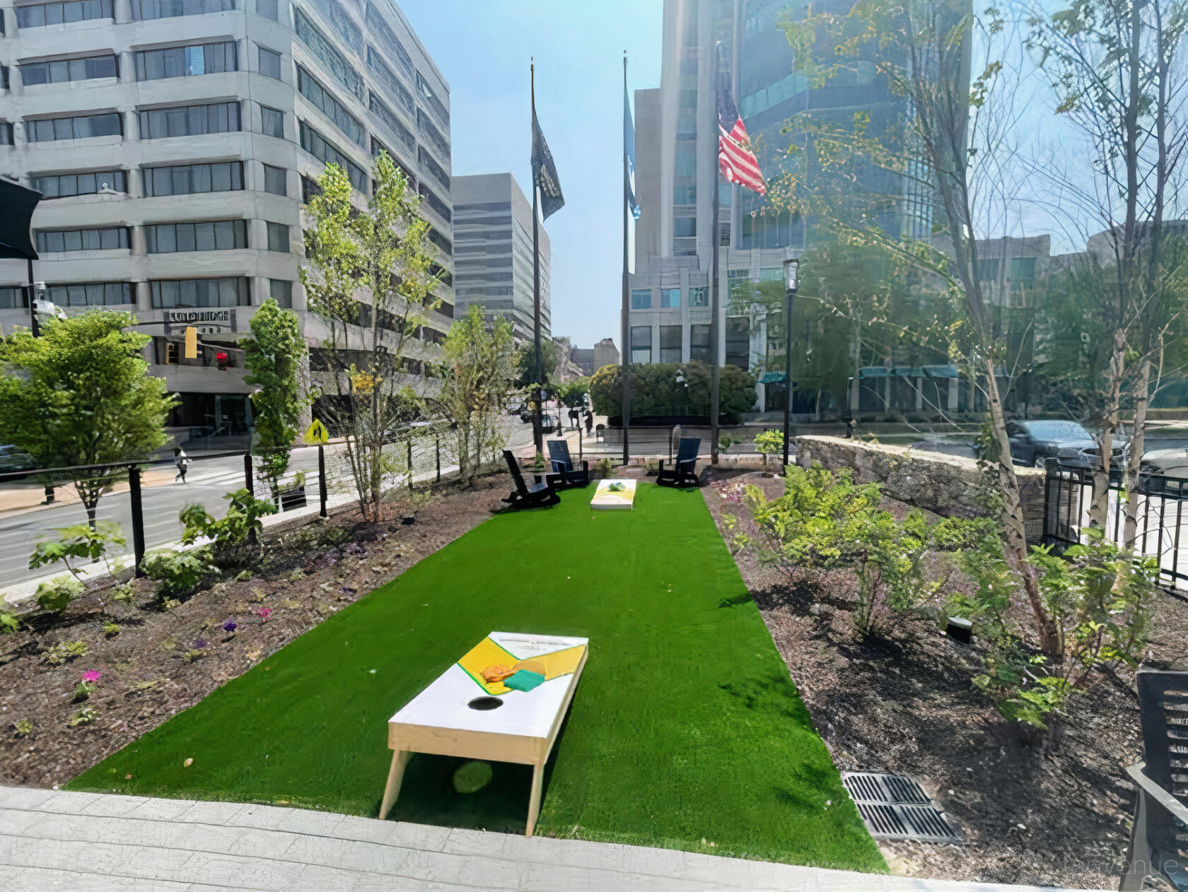 An outdoor space with artificial turf, cornhole boards, and Adirondack chairs at The Chancery Market.