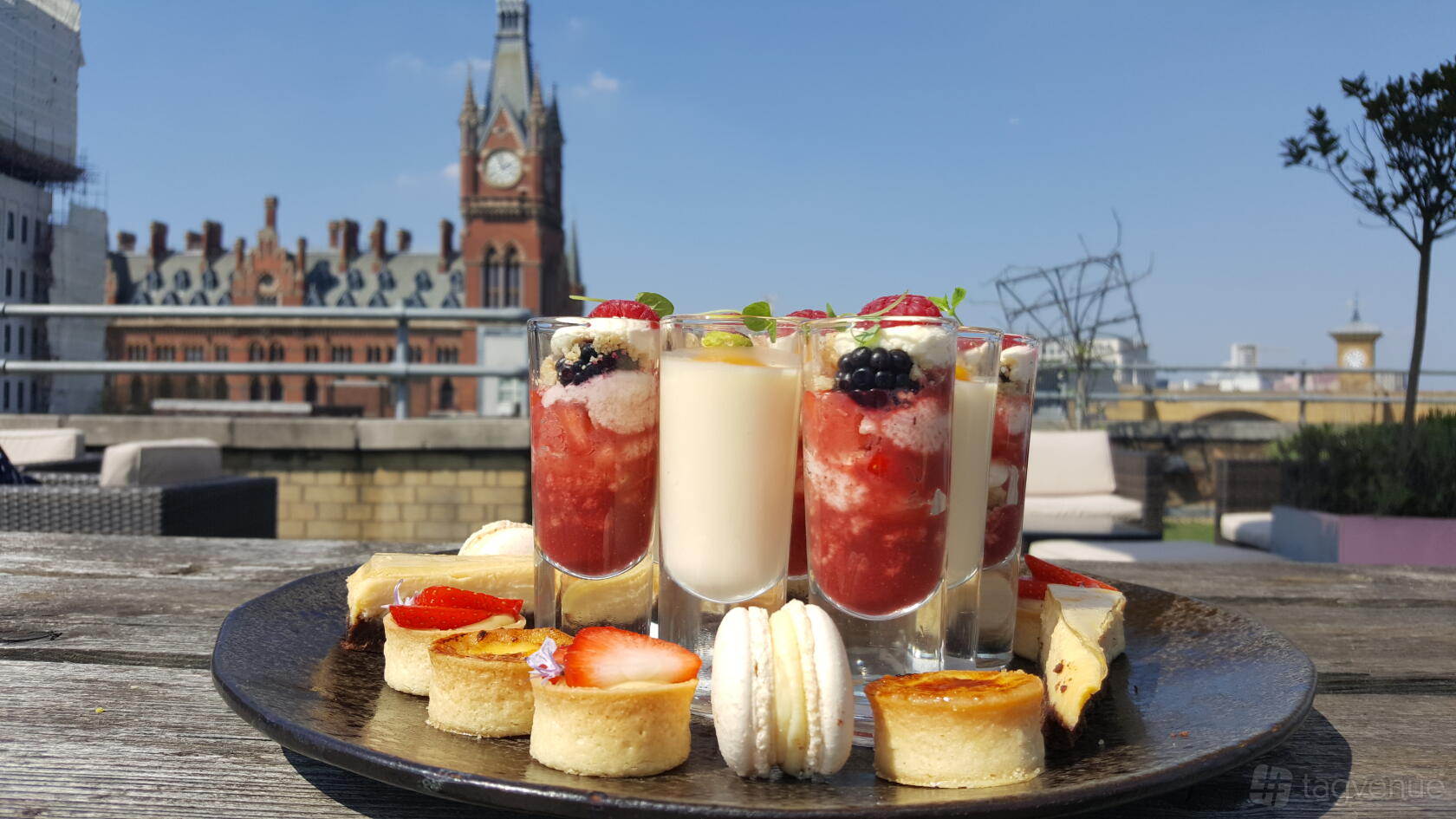 An outdoor rooftop venue with assorted desserts and cityscape views at The Derby Rooftop.
