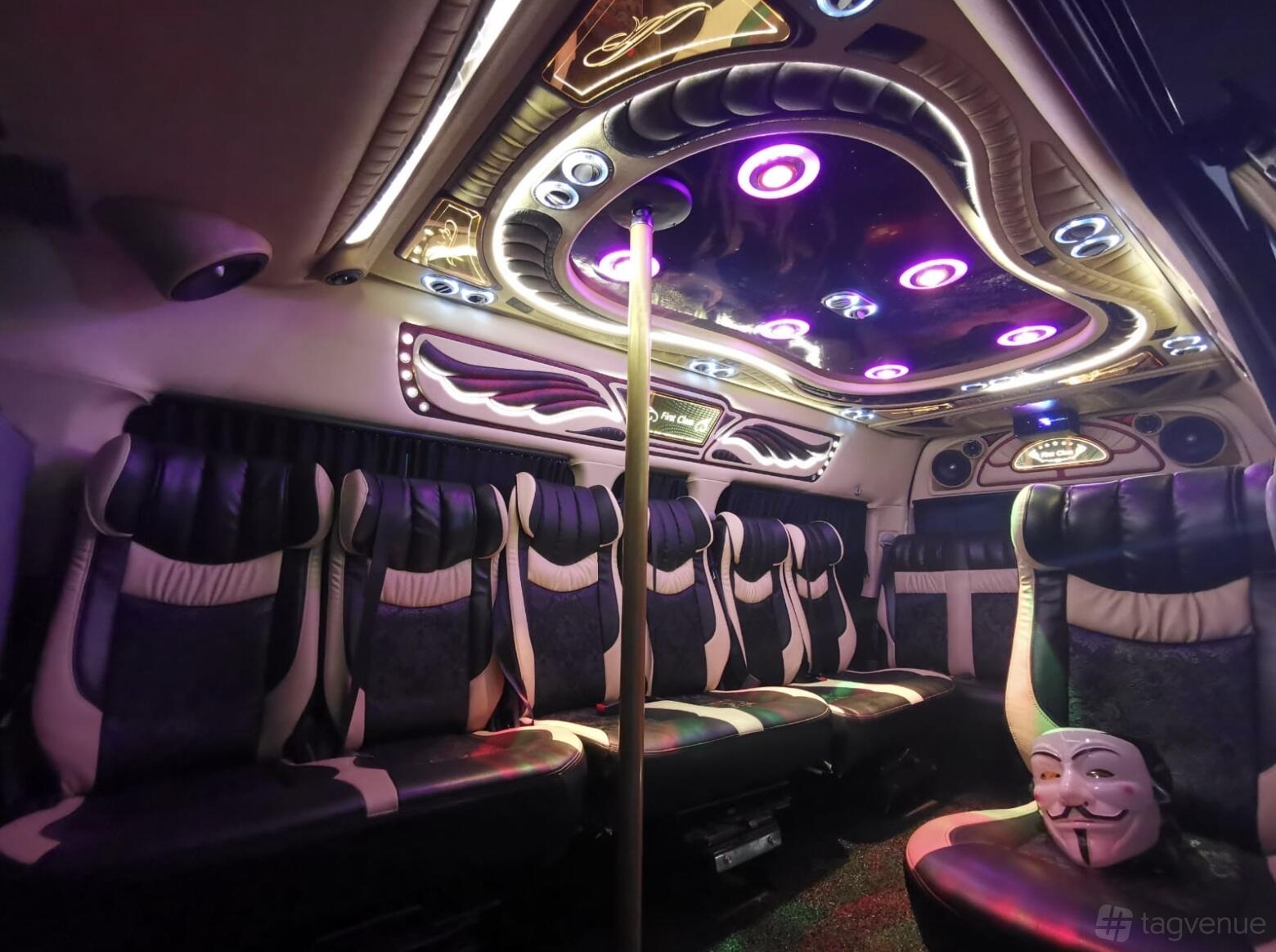 A party bus with black leather seats, LED ceiling lights, and a dance pole at Singapore Party Bus.