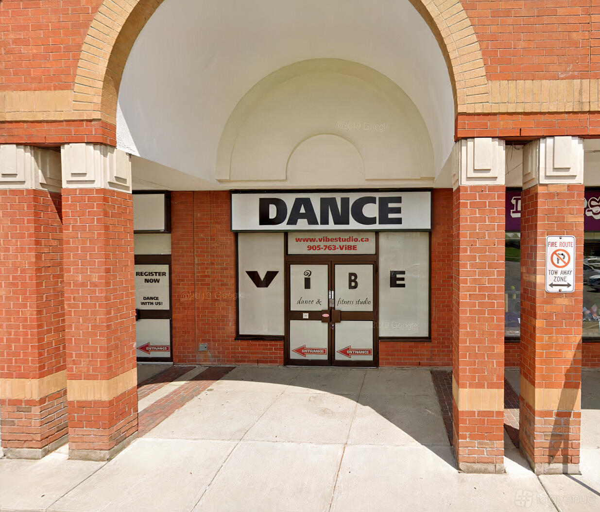 An entrance to a dance studio with large signage and brick arches at ViBE Dance Studio.