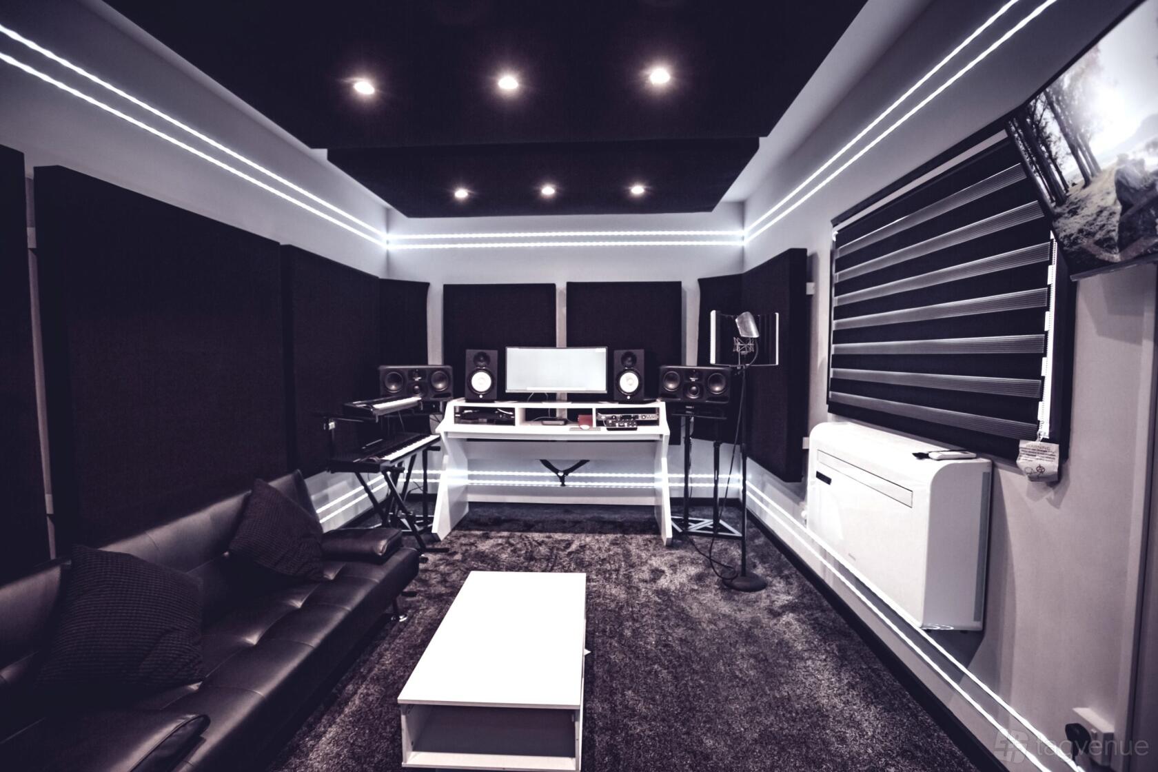 A recording studio with soundproofed walls, LED ceiling lights, and a mixing console at JNStudios.