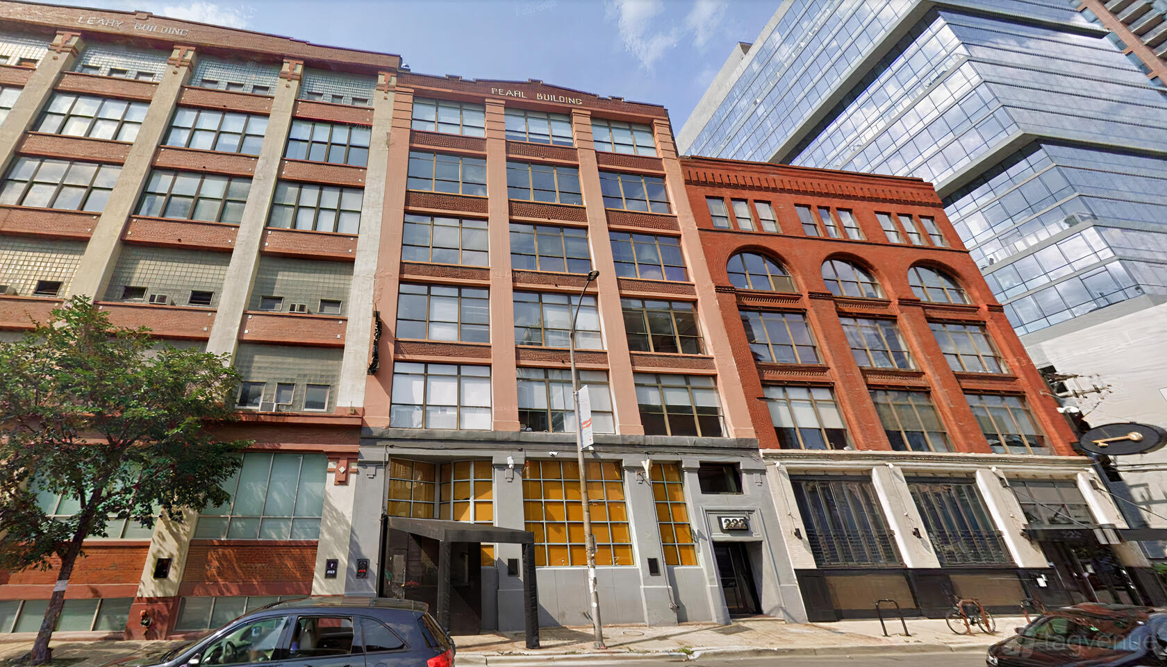 A bar with a street-level entrance set in a brick and stone building facade at Y Bar.