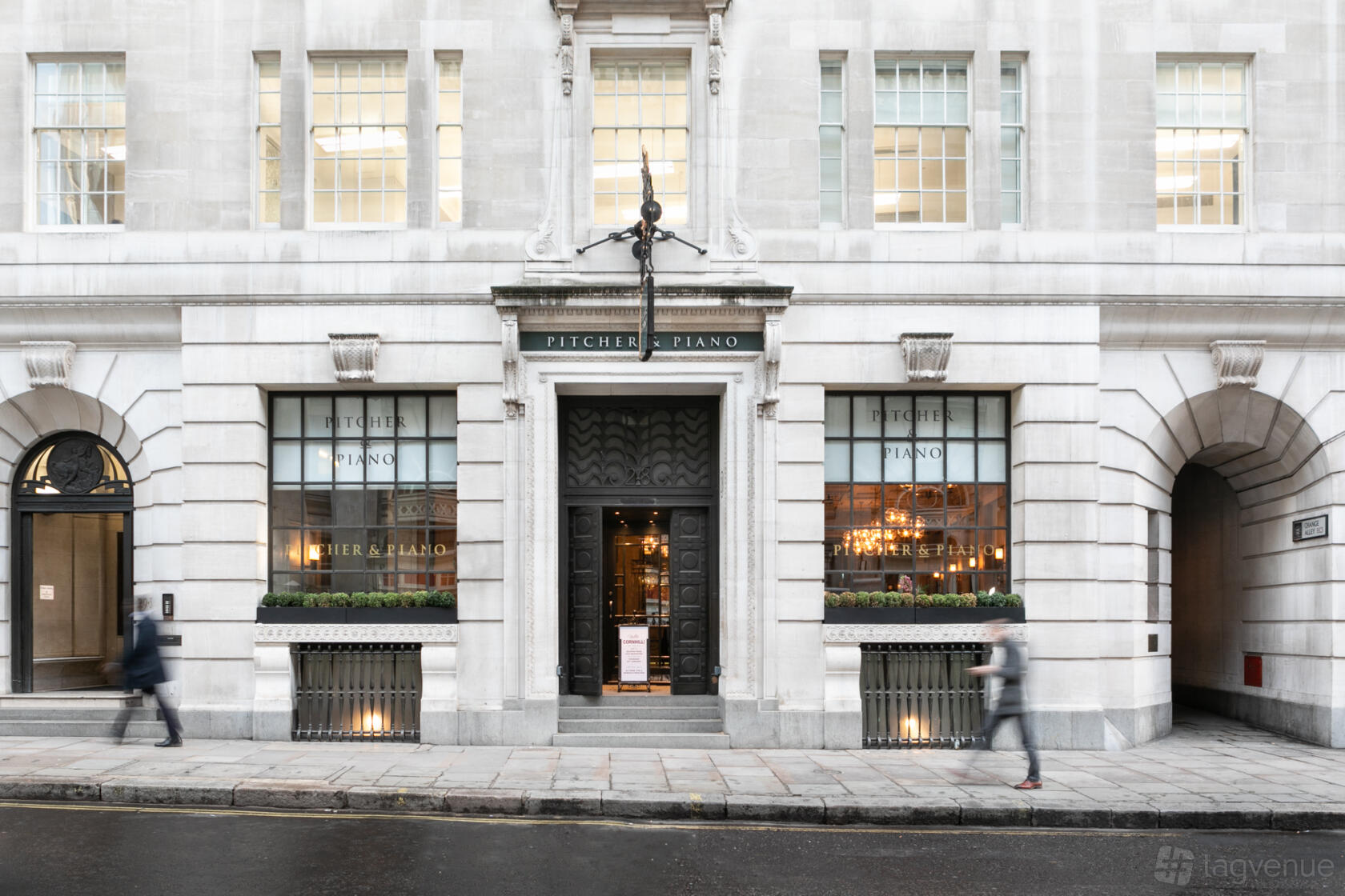 A pub with a grand stone facade, tall windows, and double doors at Pitcher & Piano Cornhill.
