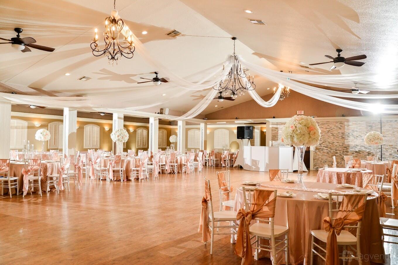 An event venue with draped white ceilings, chandeliers, and round tables with blush linens at Lindsay Lakes Lodge.