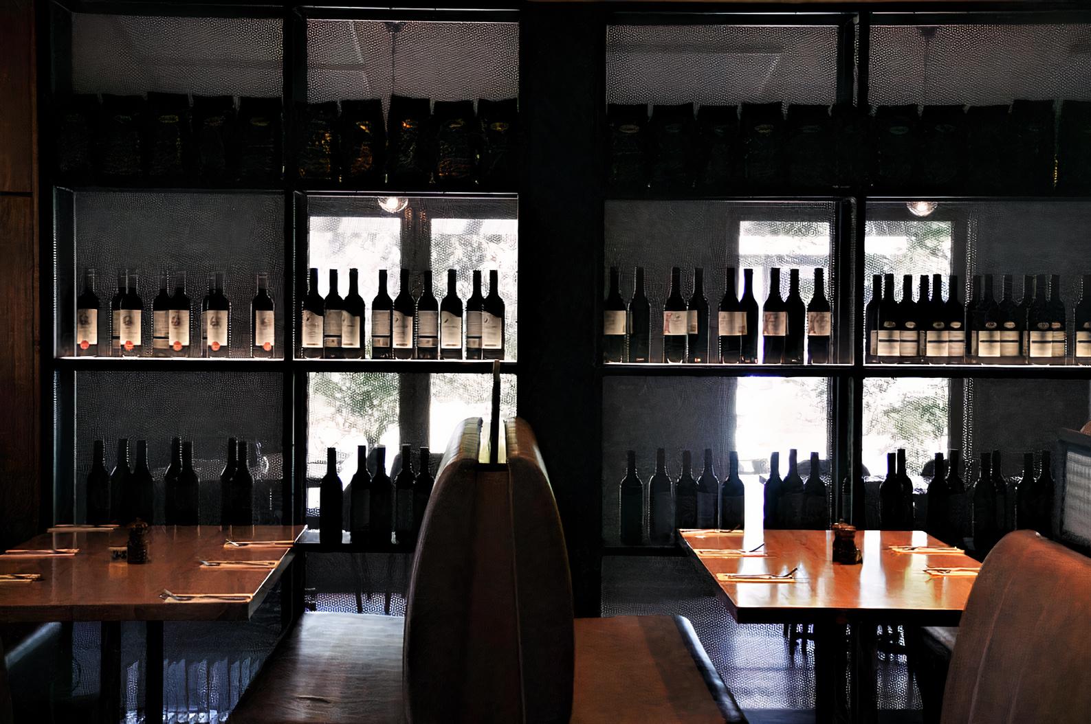 A restaurant lounge with booth seating and shelves lined with wine bottles at Dandenong Pavilion.