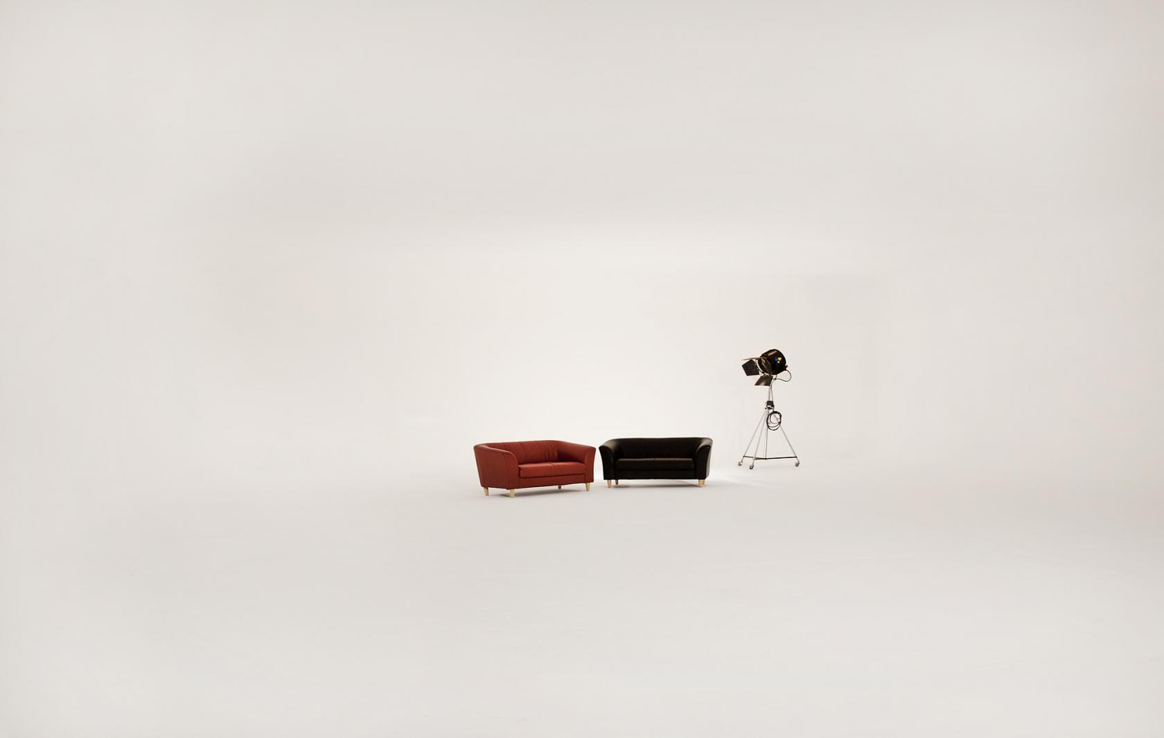 A photo studio with a seamless white cyclorama, two armchairs, and a spotlight at Filmsets Studio.