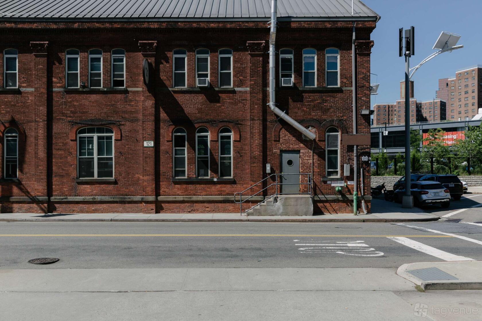 An apartment building with red brick exterior, arched windows, and metal roof at Casa Demo.