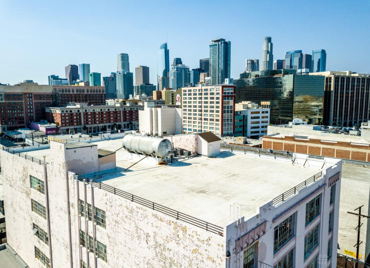 A rooftop with open white concrete flooring and city skyline views at Drip Studios.