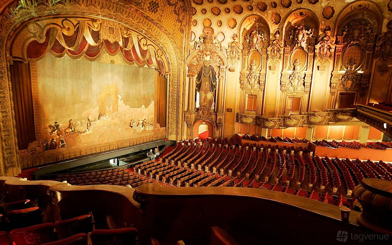 A historic theatre with ornate gold detailing, plush red seats, and a grand proscenium stage at Los Angeles Theatre.