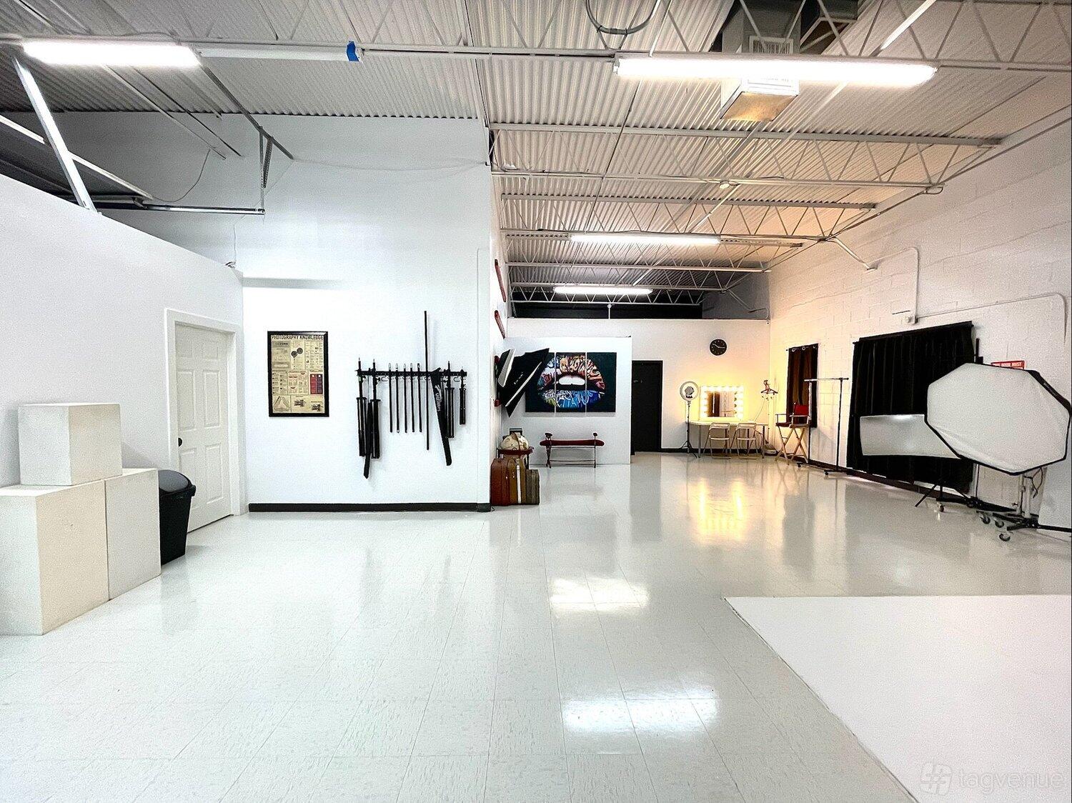 A photo studio with white walls, seamless backdrops, studio lighting equipment, and props at Vision Light Studio.