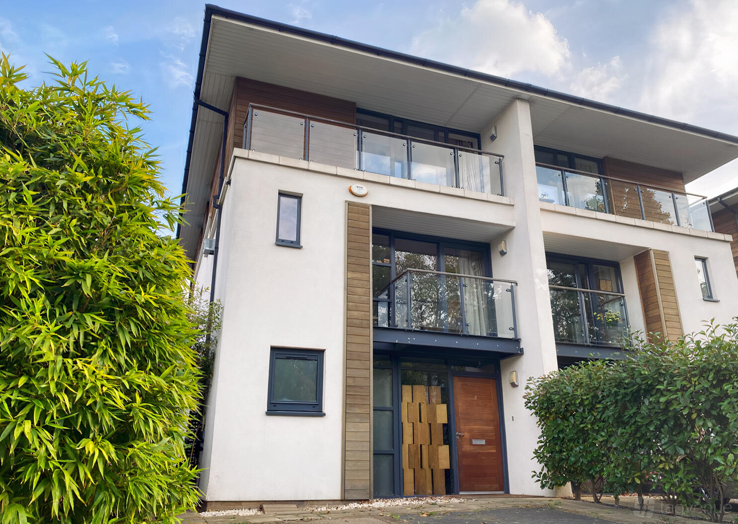 A penthouse with glass balconies, wood panel accents, and large windows at Whitelands Crescent.