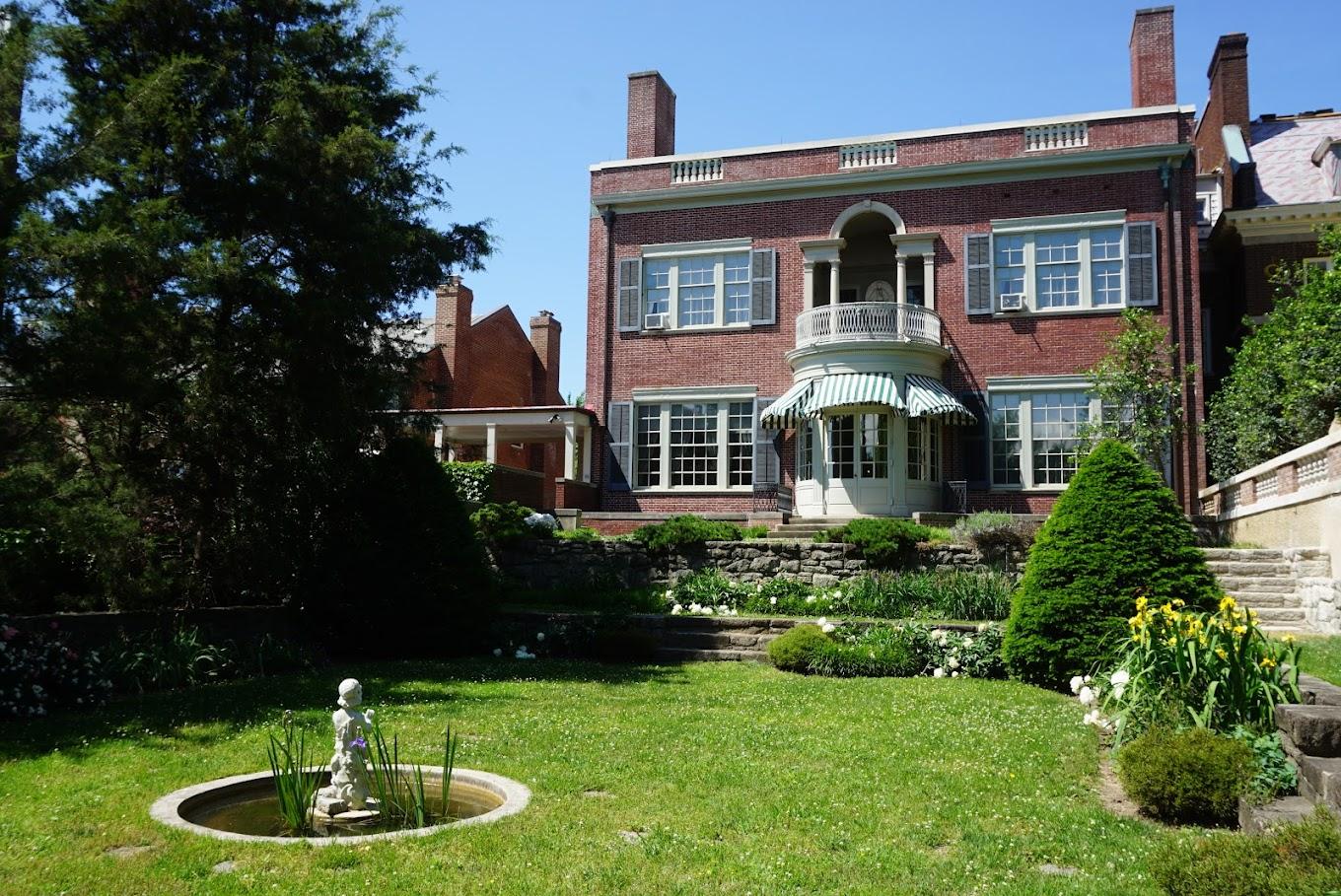 A museum garden with manicured lawns, flower beds, and a small fountain at President Woodrow Wilson House.