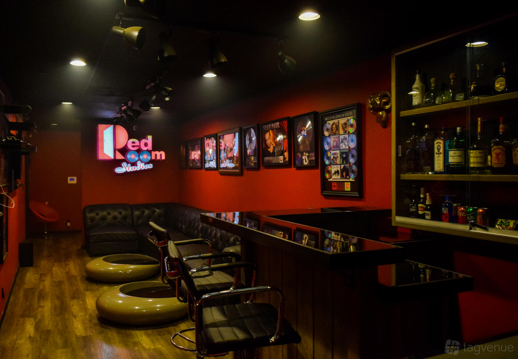 An event space in a recording studio with black leather sofas, framed music memorabilia, and a bar at Red Room Studios.