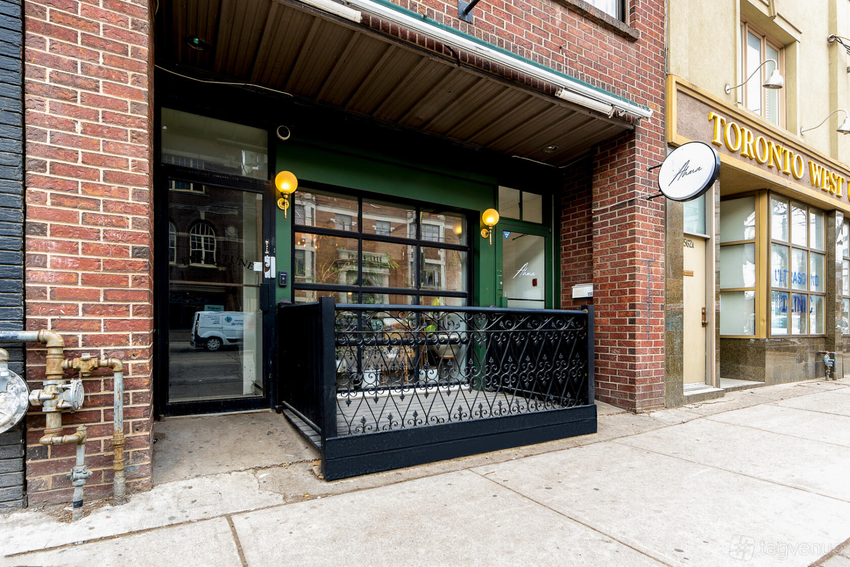 An event space entrance with a black metal railing and green facade at Ahma Toronto.