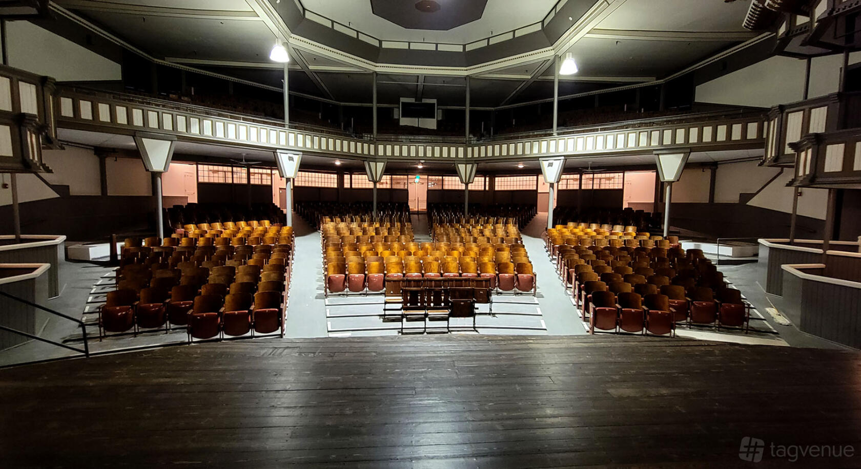 A classic theatre with wooden audience seating, balcony level, and exposed beams at Historic Elitch Theatre.