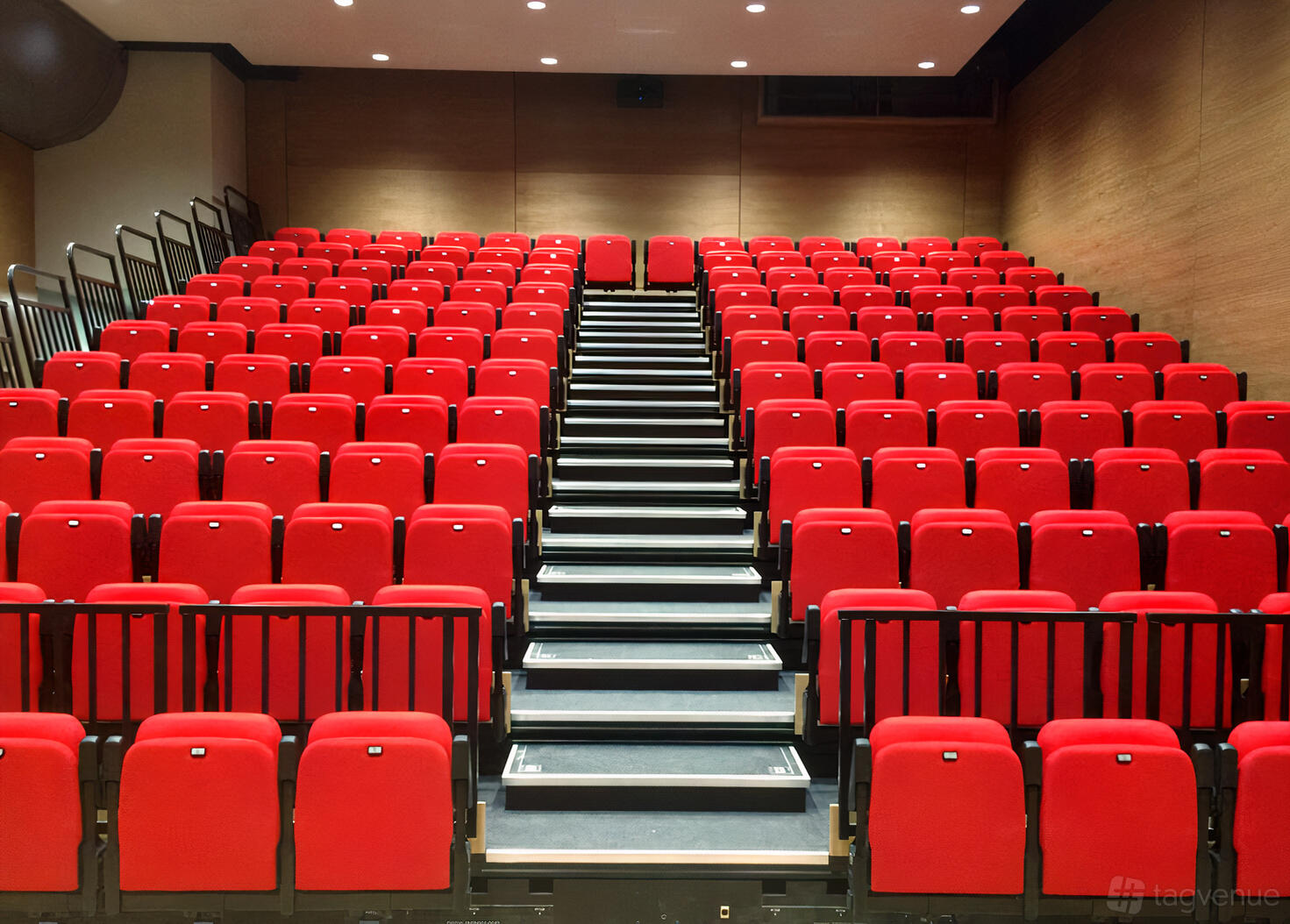 An event space in a museum with tiered rows of red auditorium seats and wood-paneled walls at Aerospace Bristol.