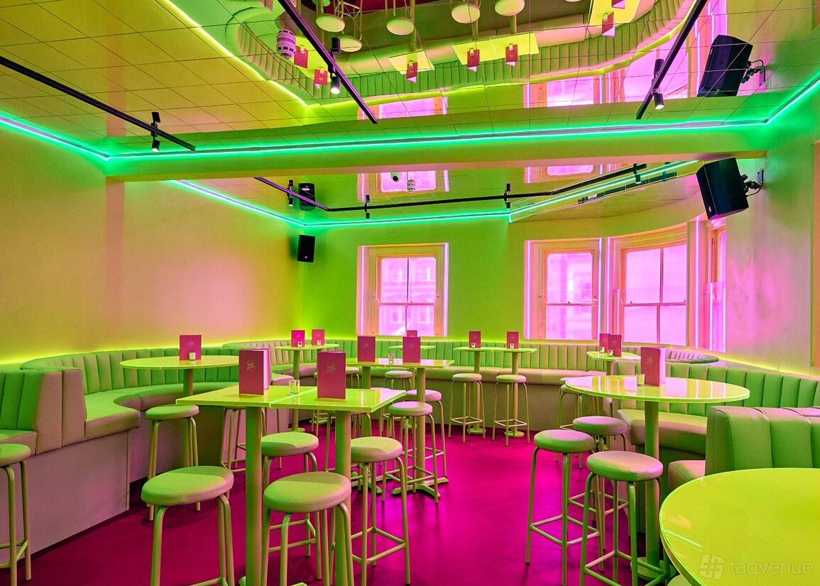 A cocktail bar with neon green lighting, mirrored ceiling, and booth seating at Tonight Josephine Cardiff.