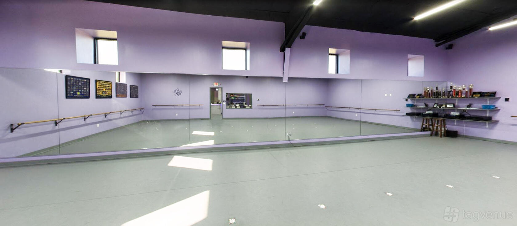 A dance studio with floor-to-ceiling mirrors, ballet barres, and lavender walls at Dance Expressions.