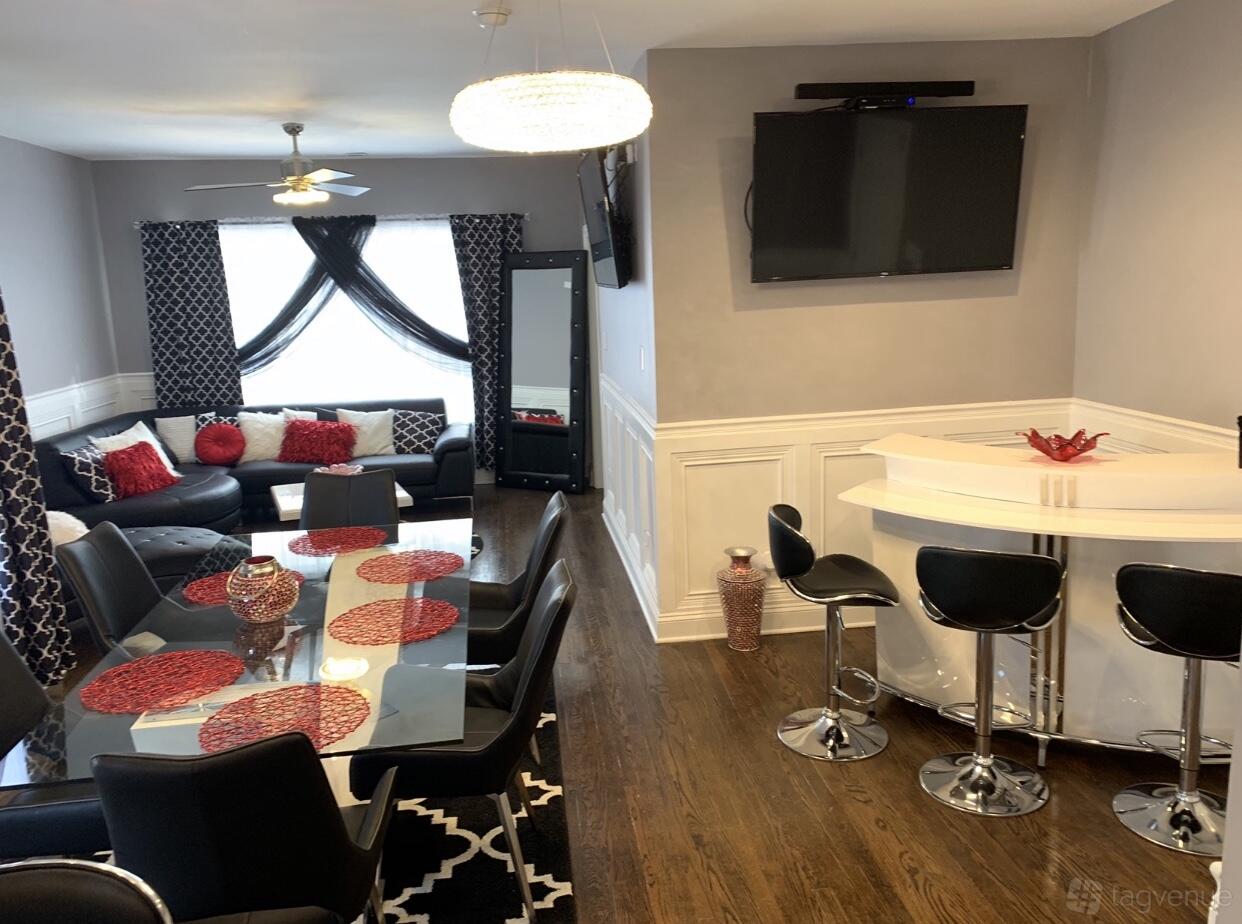 An event venue with a dining area, glass-topped table, bar seating, and a lounge with sectional sofa at L. May Creations.